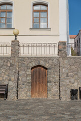 A stone wall with large wooden doors closed.