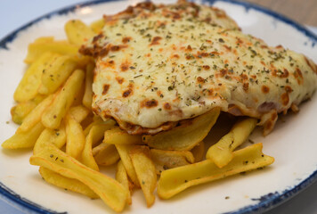 Breaded veal cutlet with ham and cheese on top, Neapolitan Milanese style