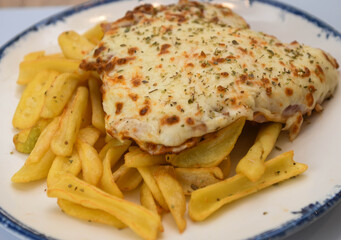 Breaded veal cutlet with ham and cheese on top, Neapolitan Milanese style