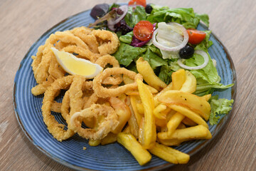 Fried squid rings with french fries and salad