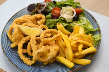 Fried squid rings with french fries and salad