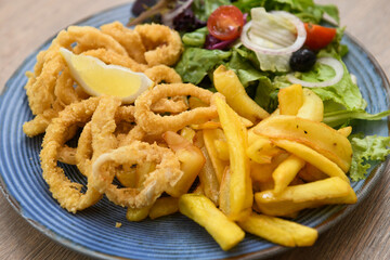 Fried squid rings with french fries and salad