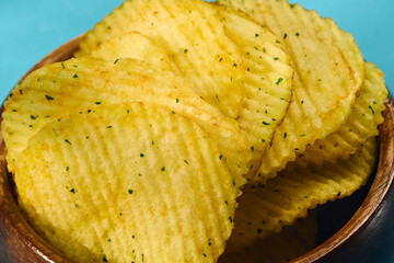Golden potato chips are layered neatly, showcasing their ridged texture