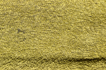 Close-up view of textured yellow fabric showcasing intricate patterns and fibers. Ideal for backgrounds, fashion, or decoration. Perfect for design projects requiring vibrant colors.