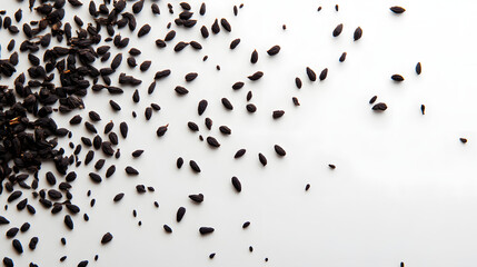 Fototapeta premium Nigella seeds scattered randomly on a white surface, their irregular forms creating a beautiful organic pattern.
