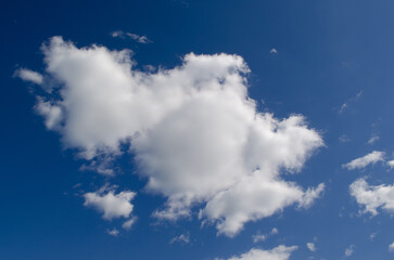 A fluffy white cloud floats in a clear blue sky. The scene captures a serene and peaceful...