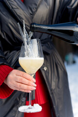 pour champagne into a glass with ice