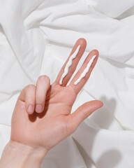 Two Finger Sunscreen Rule on White Fabric Background