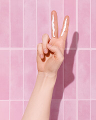 Two Finger Sunscreen Rule Concept on Pink Background