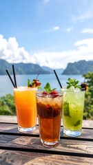 Three colorful cocktails on a wooden table overlooking a lake
