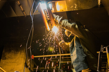 Metal soldering by welding method. A man using a welding machine solders metal in production. 