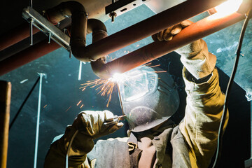 Metal soldering by welding method. A man using a welding machine solders metal in production. 