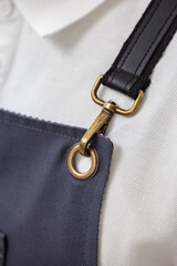 Macro of apron strap with brass carabiner detail of style and quality