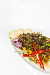top view of stewed meat with potatoes and onions, an appetizing dish on a white plate