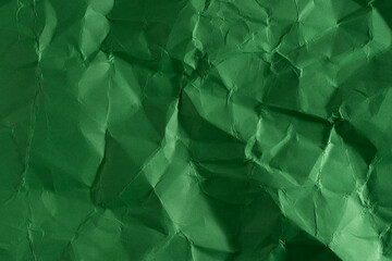 Green creased crumpled paper background grunge texture backdrop.