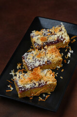Coconut Dessert Bars on a black plate.