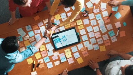 Top view of smart business team shaking hand or making agreement at meeting table with tablet display wireframe prototype for mobile phone or computer. Aerial view of team working together. Symposium. - Powered by Adobe
