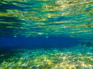 Ocean blue underwater with sunrays, Underwater Sea Deep Water Abstract Sunshine, sea wave , clean waters in summer time, Natural underwater seascape, sand on ocean floor and water surface with sunligh