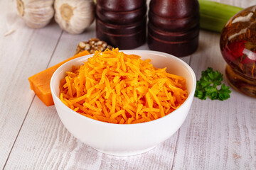 Yellow shredded cheddar cheese in the bowl