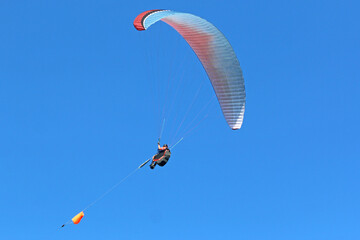 Tandem Paraglider flying in a blue sky