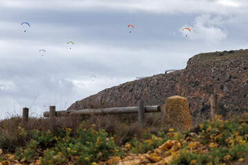 Paisaje con el mirador de Santa Pola y seis personas no reconocibles practicando parapente, Espa&ntilde;a