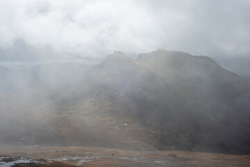 Misty foggy hills mountains in Scotland dramatic landscape hiking tourism active hillwalking