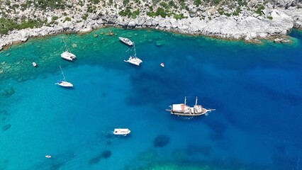 Fototapeta premium Aerial View of Anthony Quinn Bay – Boats, Crystal Waters, and Rocky Coastline