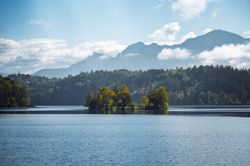 Tranquil islet "Kleine Birke" on serene Lake Staffelsee in autumn light with the Bavarian Alps in the background, perfect for travel promotion in "Blaues Land" and Werdenfels.