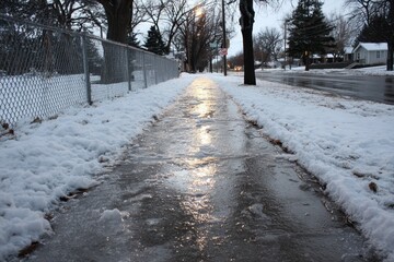 Glistening Winter Pathway: Slippery Ice Covered with Snow Invites Adventurous Walks in the Cold Season