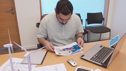 Project Manager Analyzing Data Charts for a Renewable Energy Initiative - Powered by Adobe