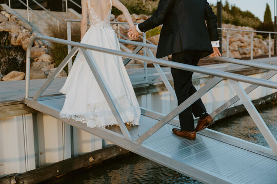 Newlywed Couple Walking at Sunset off of Boat Dock