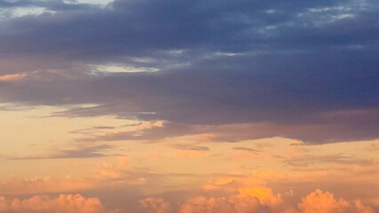 Obraz premium The East horizon displays a final high-contrast scene: dark Altostratus above and small Cumulus fragments catching the intense orange and pink afterglow of the sunset.