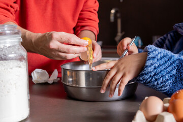 Close up of dad cracking an egg to teach his child how to cook