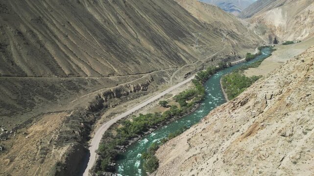 The Kokemeren river running through the picturesque landscape of Kyzyl Oi Village, Kyrgyzstan. Mountains are in the background.