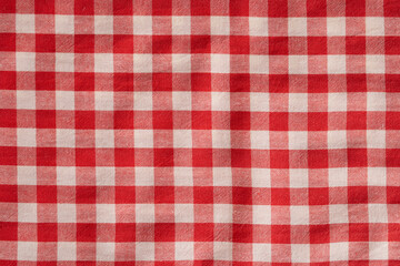 Red and white checkered fabric with classic gingham pattern commonly used in clothing, tablecloths and home decor.