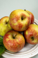 New harvest of french sweet red green apples, tasty healthy fruits on plate