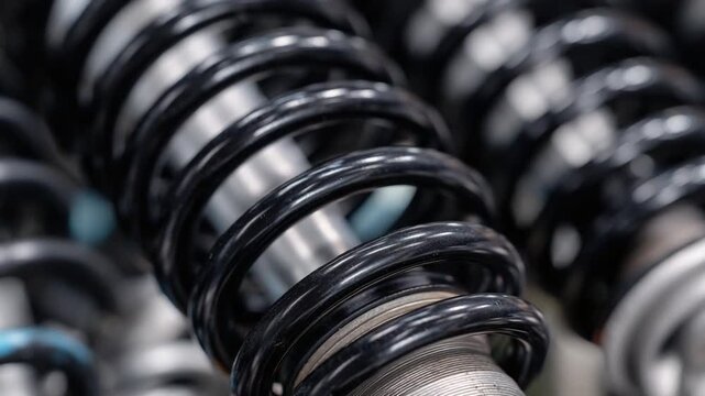 Captivating close-up of aligned valve springs, highlighting shiny black coils in an industrial car repair theme.