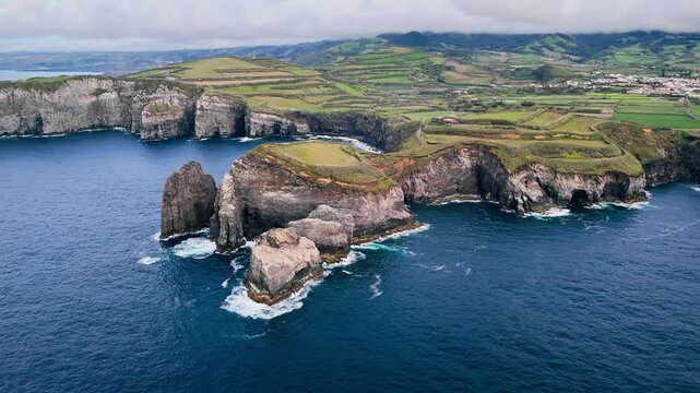 Dark blue Atlantic water meeting basalt cliffs on Sao Miguel Island, Azores, aerial view. Rocky shoreline suitable