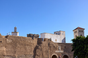 In El Jadida, historic walls and traditional buildings rise against a clear blue sky. The scene captures the rich heritage and culture of this coastal city in Morocco