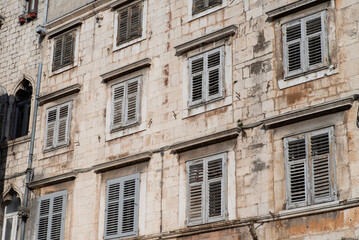 Fototapeta premium Aged stone building with gray wooden window shutters