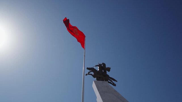 Detail of the national flag of Kyrgyzstan waving in the wind on a clear day.