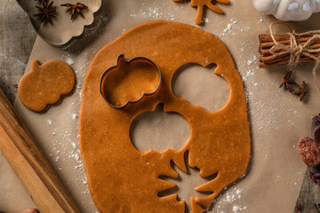 Making cookies for Halloween top view. Cut out cookies from dough in form of pumpkin and spider