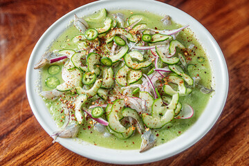 Mexican seafood called aguachile, raw shrimp dipped in lime and green sauce