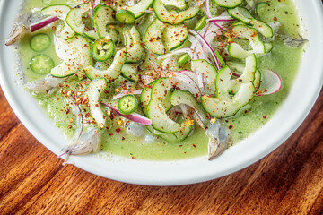 Mexican seafood called aguachile, raw shrimp dipped in lime and green sauce