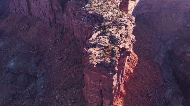 Aerial view of the sunlit canyon cliffs, their rugged textures and deep shadows creating a compelling landscape, Moab, Utah, United States.