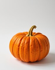 Obraz premium A perfectly formed pumpkin sits on a clean white background, showcasing its vibrant orange hue and intricate details, harvest, gourd, closeup