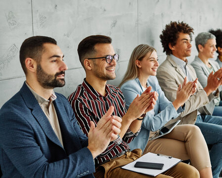 Group of young businesspeople applauding during a speech or a ceremony