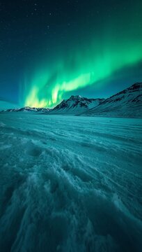 Uma bela paisagem de natureza com o sol nascendo sobre o oceano azul entre montanhas e picos nevados dos Alpes com ondas suaves no mar sob um c&eacute;u de nuvens no inverno