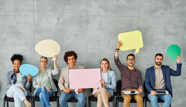 Portrait of a group of young business people in office. Speech bubble, team and comment by business people holding sign, news and voice icon feeling excited on social media. Group, opinion and poll by