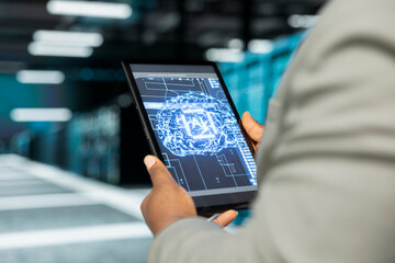 Close up of data center admin using artificial intelligence computerized model on tablet simulating human brain. Server farm IT professional working with AI machine learning algorithms on device